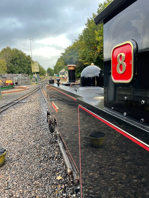 Looking down the side of the black engine, with the tracks disappearing off into the distance. It’s a very skewed perspective.